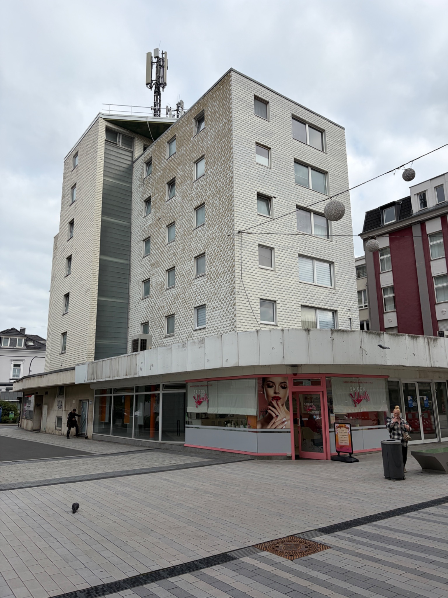 Werth 65 mit heller Fassade und Ladenfronten im Erdgeschoss